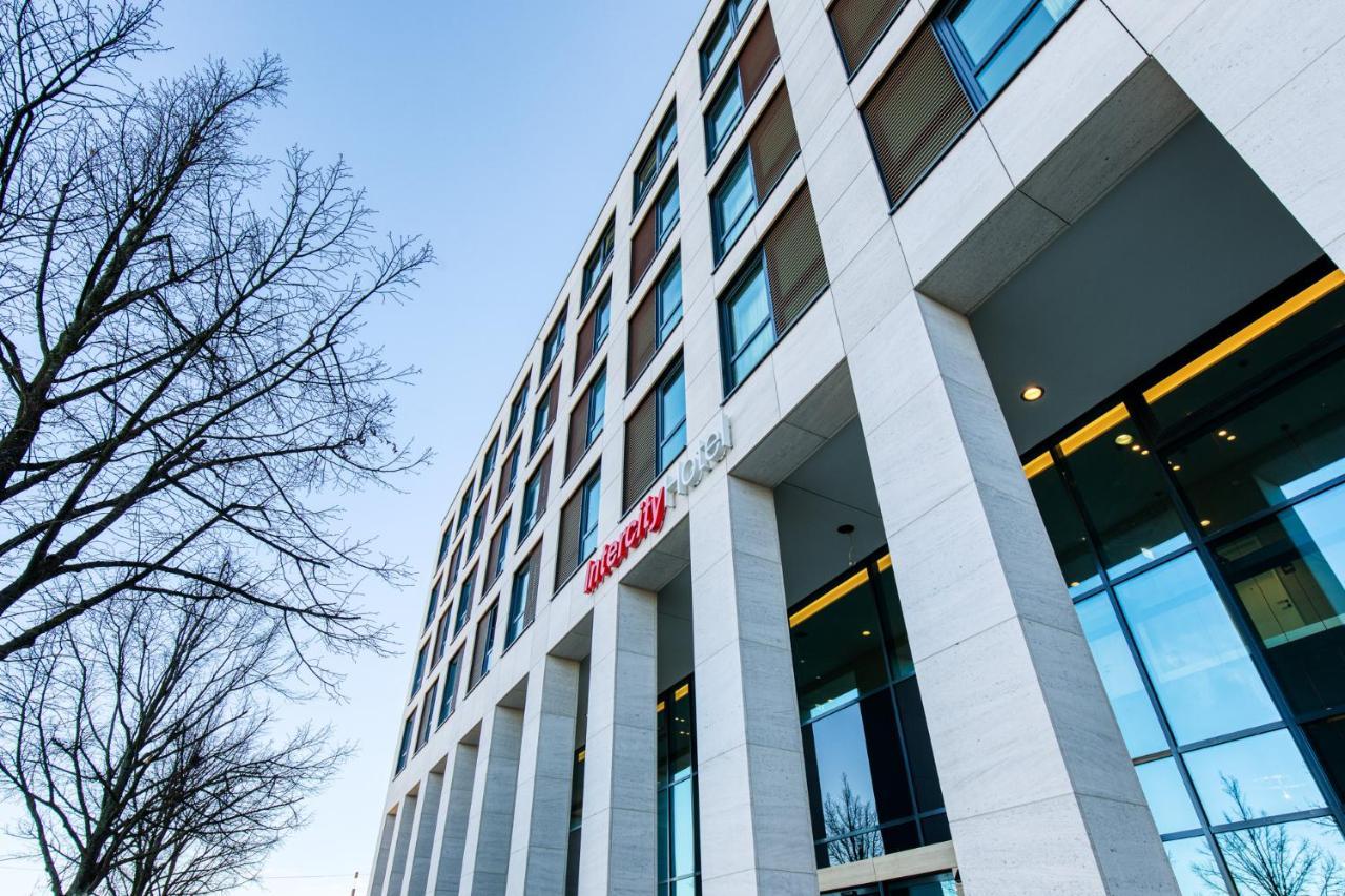 Intercityhotel Berlin Airport Ber Terminal 1 & 2 Schönefeld Extérieur photo The photo shows a modern building with a sleek, contemporary design. The structure features several large windows and a façade composed of light-colored stone. There is a visible entrance with glass doors, and the building appears to be several stori